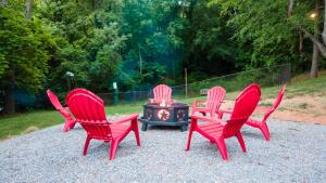 three red chairs sitting around a fire pit at Log Cabin Motor Court in Asheville +3 photos