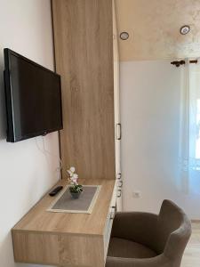 a living room with a tv and a chair at Apartman Zara Zlatar in Nova Varoš