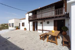 - un patio avec une table en bois et un bâtiment dans l'établissement Villa Rural La Zarza by Sunkeyrents, à Fasnia