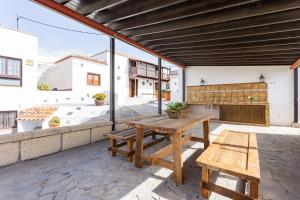 een patio met een houten tafel en banken bij Villa Rural La Zarza by Sunkeyrents in Fasnia