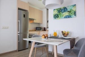 uma cozinha com uma mesa branca e cadeiras num quarto em Apartamentos Aura Park Fira BCN em Hospitalet de Llobregat