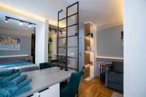 a bedroom with a bed and a desk with green chairs at Apartman Pale centar Free parking in Pale