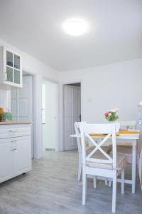 マコーにあるJázmin Apartmanの白いキッチン(白いテーブルと椅子付)
