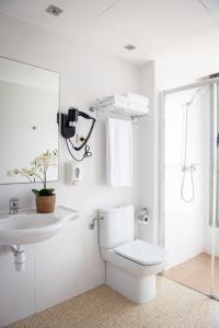 a white bathroom with a toilet and a sink at Apartamentos Aura Park Fira BCN in Hospitalet de Llobregat