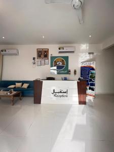 阿爾哈德的住宿－السكون لبيوت الضيافة و شاليه AL Sukun For Guest Houses & Chalet，一间设有一张沙发和一个柜台的商店的房间