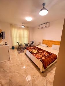 una camera con un grande letto e un tavolo con sedie di السكون لبيوت الضيافة و شاليه AL Sukun For Guest Houses & Chalet a Al Ḩadd
