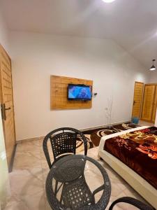 Cette chambre comprend un lit et une télévision murale. dans l'établissement السكون لبيوت الضيافة و شاليه AL Sukun For Guest Houses & Chalet, à Ras al Hadd