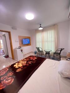 ein Wohnzimmer mit einem Bett, einem Tisch und Stühlen in der Unterkunft السكون لبيوت الضيافة و شاليه AL Sukun For Guest Houses & Chalet in Ras al-Hadd