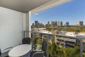a balcony with tables and chairs and a view of the city at Mantra South Bank Brisbane in Brisbane