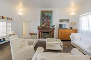 a living room with white furniture and a fireplace at Villa Almar in Cala d´Or