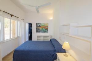 a bedroom with a blue bed and a window at Villa Almar in Cala d´Or