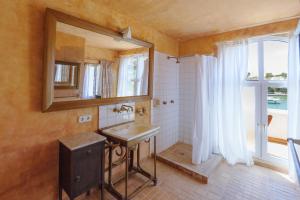 a bathroom with a sink and a mirror and a window at Villa Almar in Cala d´Or +58 photos