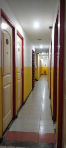 a hallway with colorful doors and a tile floor at 1st Inn Hotel Glenmarie in Shah Alam