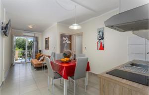a kitchen and dining room with a red table and chairs at 2 Bedroom Lovely Apartment In Pinezici in Pinezici