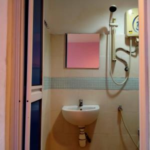 La salle de bains est pourvue d'un lavabo et d'une douche. dans l'établissement 1st Inn Hotel Glenmarie, à Shah Alam