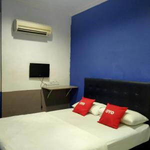um quarto com uma cama com duas almofadas vermelhas em 1st Inn Hotel Glenmarie em Shah Alam