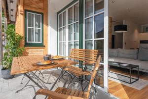 eine Terrasse mit einem Tisch, Stühlen und einem Sofa in der Unterkunft Apartment am Grundlsee in Grundlsee