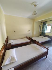 Zimmer mit 3 Betten und einem Fenster in der Unterkunft Nea Zoi in Moraḯtika