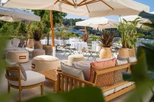 un patio con mesas, sillas y sombrillas en Hotel Supetar en Cavtat