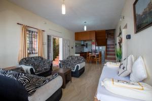 a living room with two couches and a kitchen at Syamantac Villa in Kodaikānāl