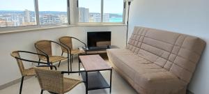 a living room with a couch and two chairs and a table at Vue Ocean in Portimão