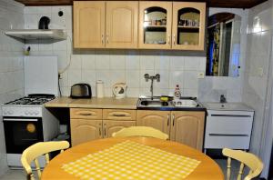 a small kitchen with a table and a sink at Unicum Vendégház in Abádszalók