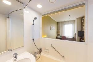 La salle de bains est pourvue d'un lavabo et d'un miroir. dans l'établissement Kichijoji Excel Hotel Tokyu, à Musashino