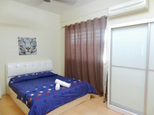 a bedroom with a bed with a blue comforter at Dream Borneo Budget Homestay Kota Kinabalu in Penampang