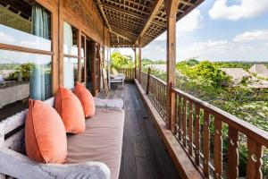 a porch with pillows and a view of the ocean at Alami Boutique Villas & Resort in Tabanan