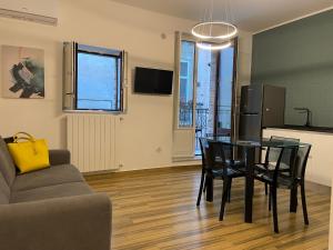Il comprend un salon avec une table et des chaises ainsi qu'une cuisine. dans l'établissement BB4U Apartments al Massimo, à Palerme