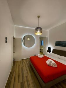 - une chambre avec un lit rouge et des serviettes dans l'établissement BB4U Apartments al Massimo, à Palerme