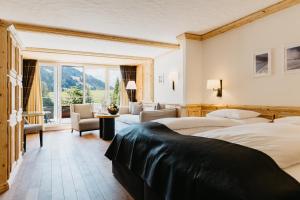 a hotel room with two beds and a living room at ERMITAGE Wellness- & Spa-Hotel in Gstaad