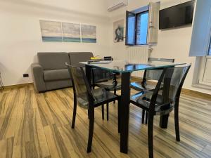 Un comedor con una mesa de cristal y sillas. en BB4U Apartments al Massimo, en Palermo 11 fotos más