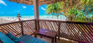a balcony with a table and a view of the beach at Ananda Beach Hotel in Paje