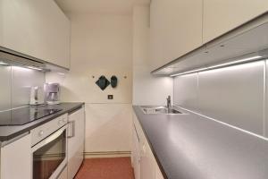 cocina blanca con fregadero y encimera en Residence Saulire, en Méribel