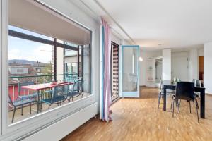 Cette chambre dispose d'un balcon avec une table et des chaises. dans l'établissement Spacious Central Apartments HOTING, à Zurich