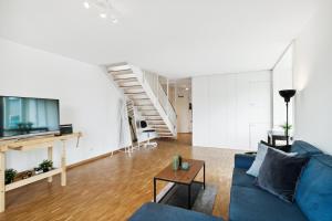 Spacious Central Apartments HOTING في زيورخ: غرفة معيشة مع أريكة زرقاء وطاولة