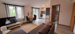 a living room with a couch and a flat screen tv at Apartmani Elena in Malinska