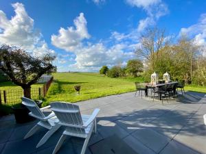 a patio with a table and chairs and a field at Kerkje van Peins in Peins