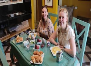 zwei Frauen sitzen an einem Tisch mit Essen in der Unterkunft Paris Hotel Cairo in Kairo