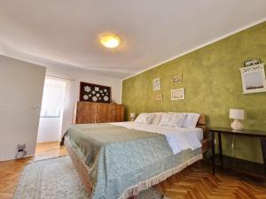 a bedroom with a bed and a green wall at House Nono Bepo in small Istrian village - Kuca Nono Bepo u mirnom istarskom selu in Brtonigla