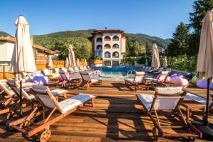 a group of chairs and umbrellas next to a pool at EMAR HOTEL & SPA in Sapareva Banya