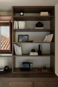 a book shelf with books and a window at The Storyteller Boutique House in Kalabaka