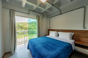 a bedroom with a bed and a large window at Antiquus ApartHotel in Guaramiranga