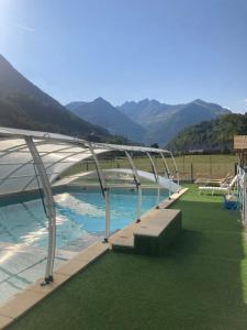 una piscina con dosel de metal y césped verde en Camping Happy Pyrénées en Saligos