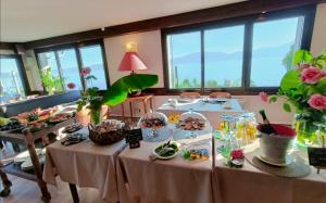ein Zimmer mit Tischen, gefüllt mit Essen und Blumen in der Unterkunft Hotel Le Léman in Saint-Gingolph