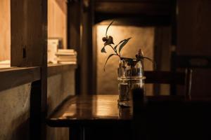un jarrón de cristal con flores en una mesa en Oito 美しい街並みに佇む喫茶と宿, en Tamba-sasayama