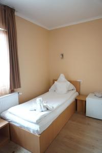 a hotel room with a bed with towels on it at Pensiunea Elias in Cluj-Napoca