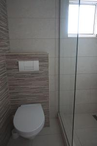 a bathroom with a toilet and a shower and a window at Pensiunea Elias in Cluj-Napoca