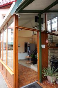 - une grande porte en verre d'un bâtiment avec une terrasse dans l'établissement Pensiunea Elias, à Cluj-Napoca